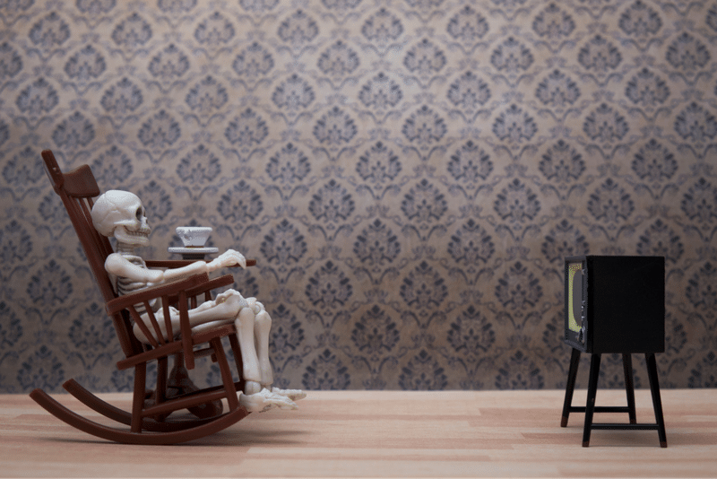 Toy skeleton watching television in rocking chair